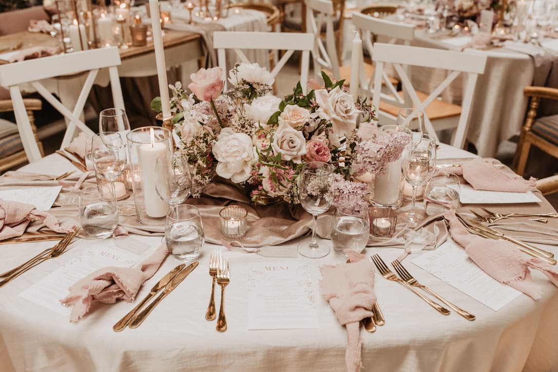 Blush and cream tablescape with gold cutlery and a low floral centrepiece